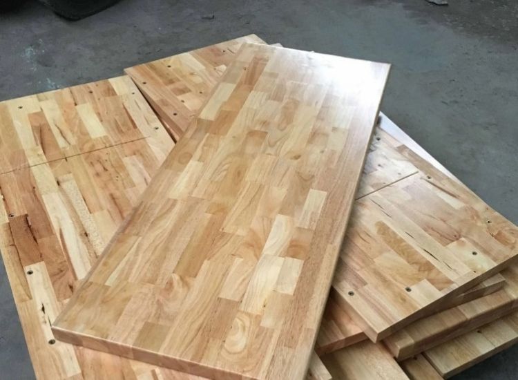 Rubber wood boards stacked neatly, showcasing their smooth finish and rich grain, ideal for furniture and home decor projects.
