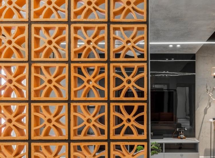 Cement jali partition design in orange shade, featuring patterns that add vibrancy and texture while enhancing the space's style.