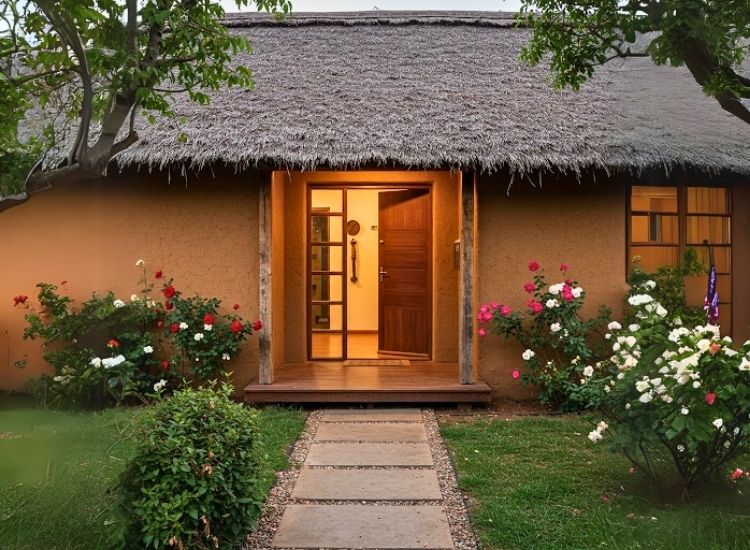 Mud walls with thatched design create a rustic, eco-friendly look for the home entrance, enhancing the house entrance design with natural charm.