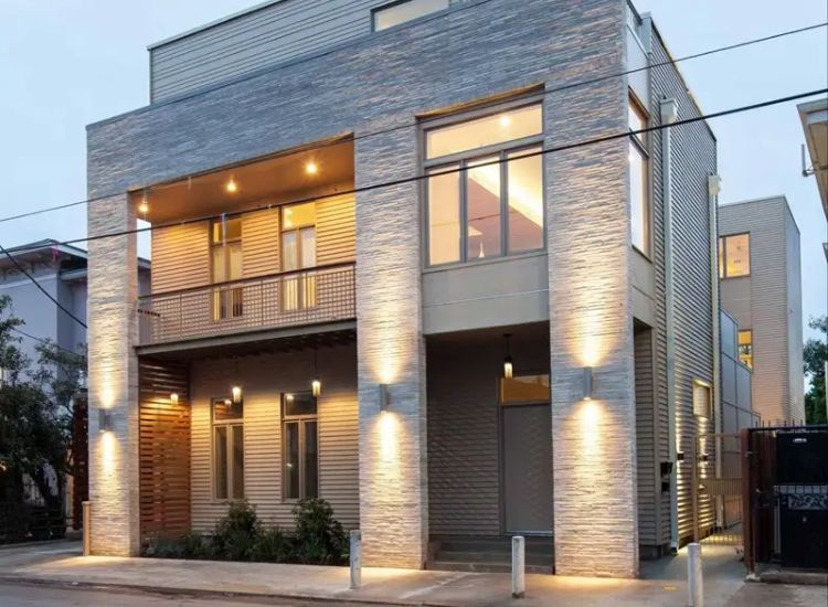 A Contemporary House Illuminated To Showcase Its Modern Architectural Design With A Spacious Front Porch And A Driveway