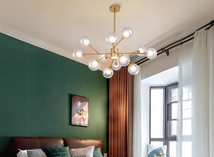 Sleek modern chandelier illuminating a stylish living room, casting warm light on minimalist furniture and vibrant decor.
