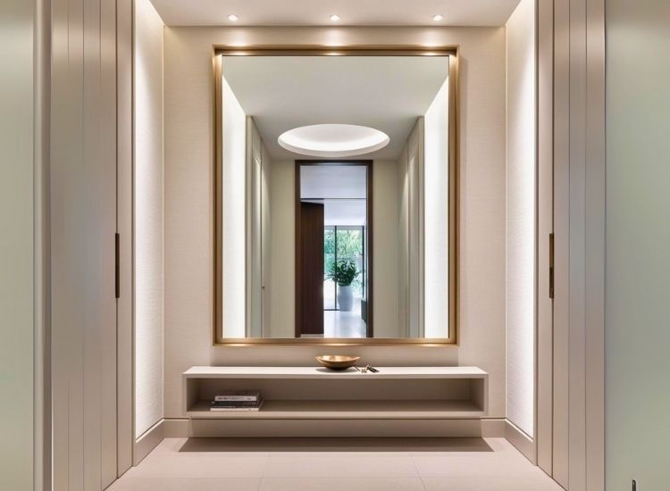 Oversized entryway mirror with shelf enhancing foyer entrance design and hallway decor with functional wall panel elements.