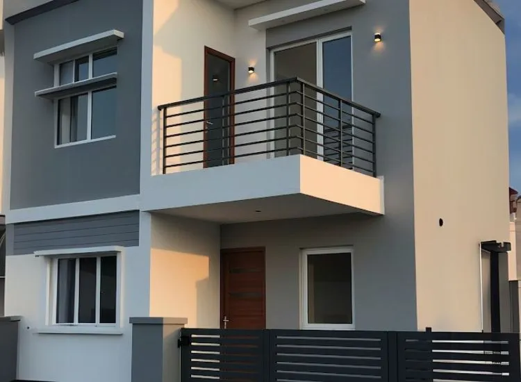 Modern home front elevation design with a small balcony and stylish metal railings, complementing the sleek double-floor exterior.