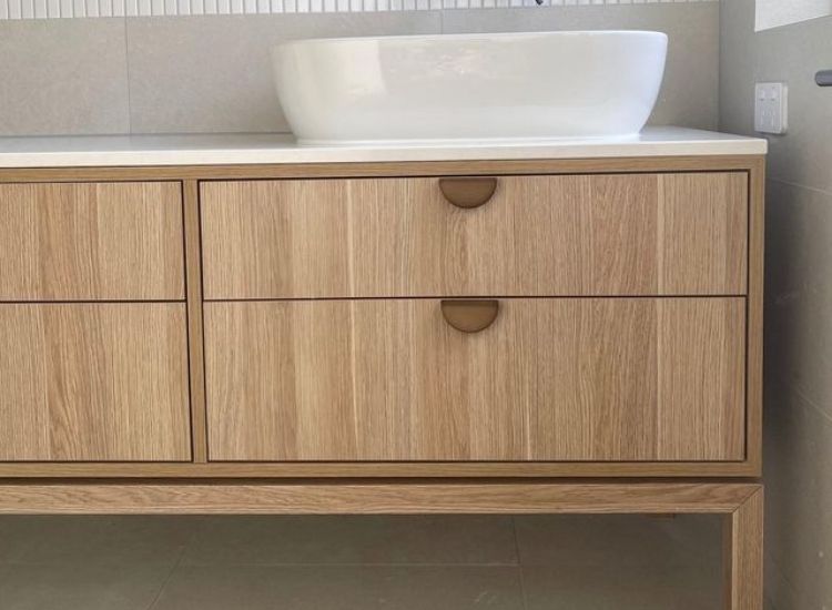 A bathroom with a sink and wooden drawers made of boiling water resistance plywood