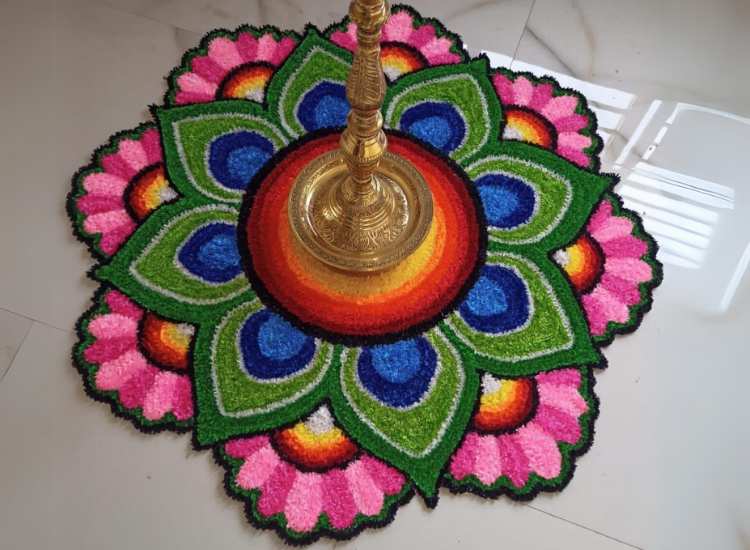 Beautiful ready-made Diwali rangoli mat at the home entrance, adorned with a brass lamp for an inviting festive touch.