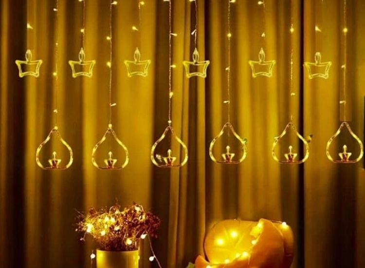 "Warm Diwali lighting images of twinkling lights framing a window, filling the room with a cozy and festive atmosphere."