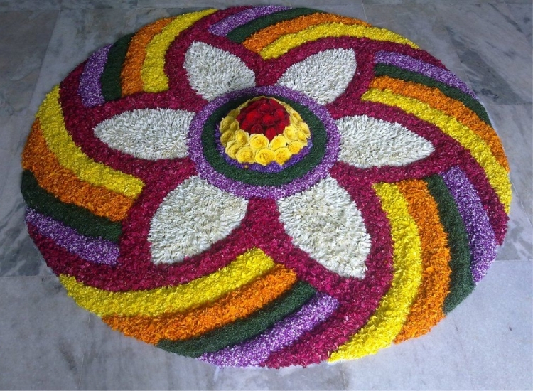 Colorful circular rangoli made with flower petals, showcasing vibrant patterns for festive decor