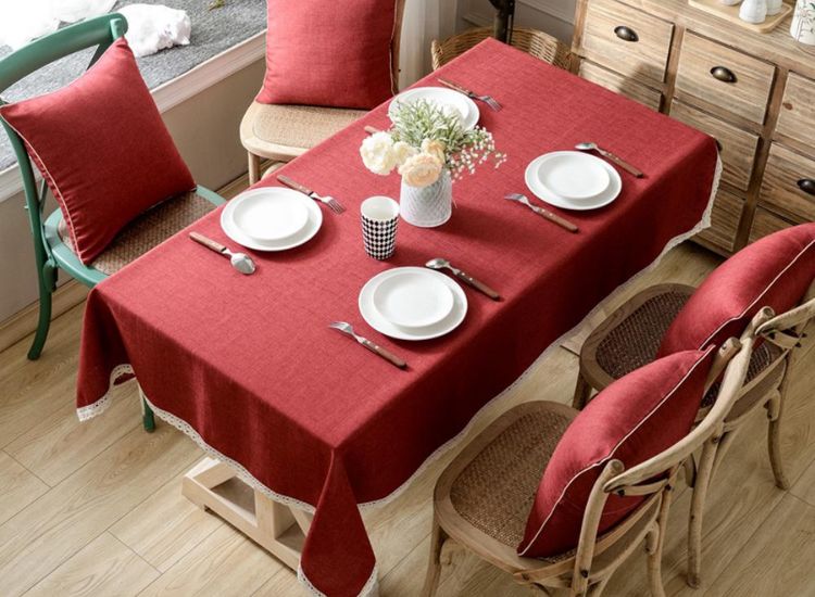 Elegant red linen tablecloth draping the table, complemented by matching cushions on the chairs for a cohesive look.