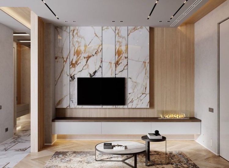 Italian marble with gold veins wall paneling enhancing the beauty of tv unit in the living room.