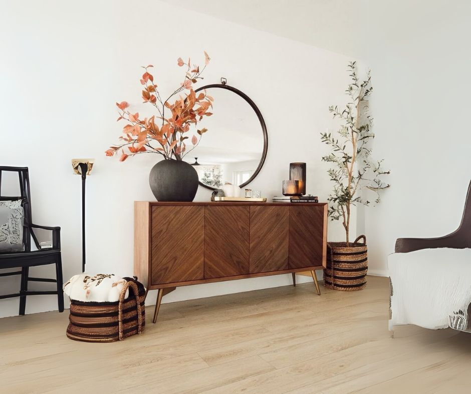 A sideboard finished with brown colored veneer with mirror and vases, creating an elegant and stylish ambiance