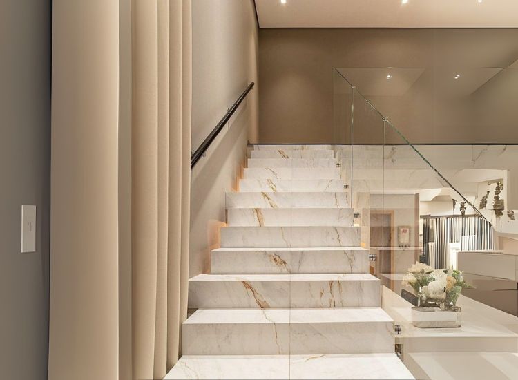 White italian marble with gold veins stairs adding drama to the staircase design of a home.